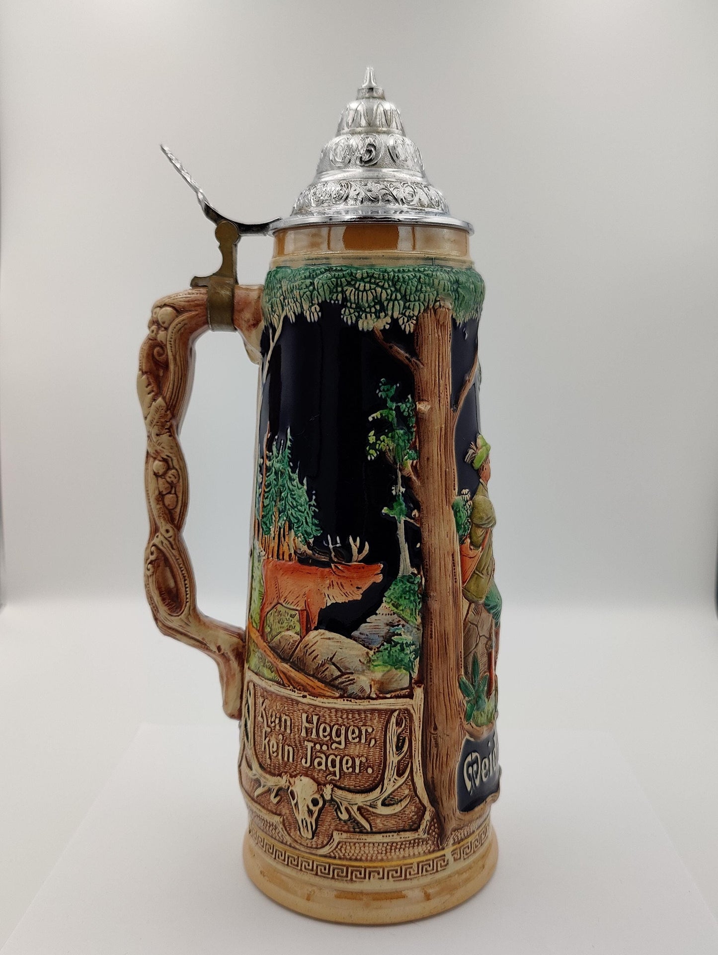 likely stoneware or ceramic with a pewter lid. Depicts a hunting scene with hunters and game.
Features the phrase "Weidmanns Heil," a traditional German hunter's greeting. A valuable item for collectors of breweriana or German antiques.