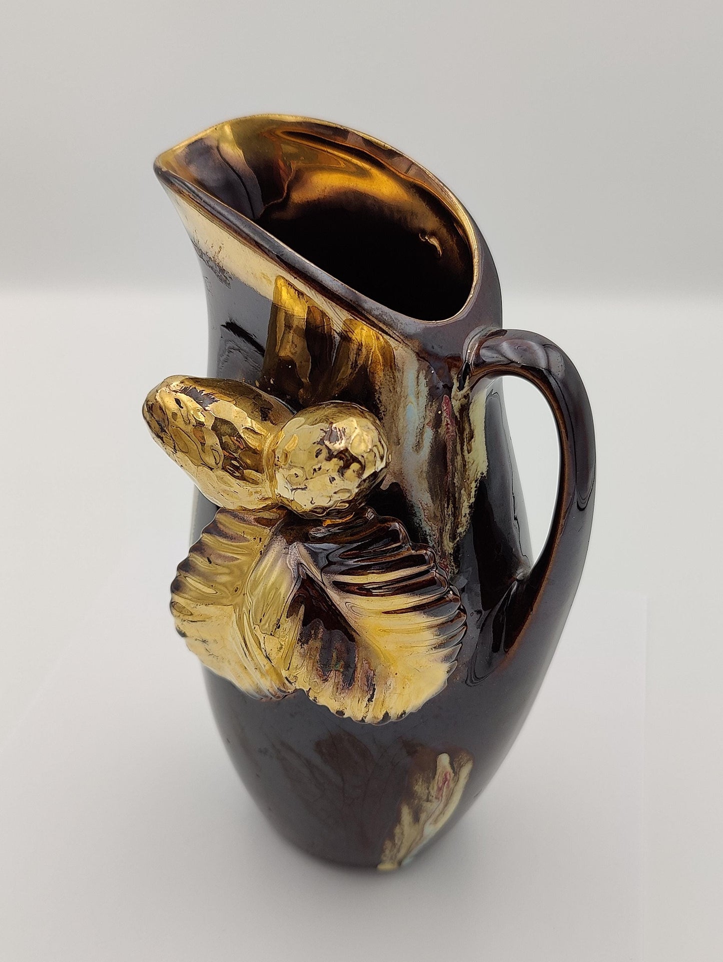 Powdered copper pitcher painted with bronze and chestnuts and leafs* attached on the side. It stands approximately 8.5" tall and 4.5" wide, about 3" long.. weighing 1 lb 1.1oz.